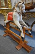 A grey painted rocking horse on pine base.
