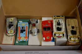 A group of six boxed models of Porsche racing cars.