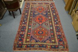 A Persian Kazak rug with three large diamond shaped medallions 225cm x 135cm.