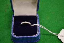 A platinum and diamond half hoop eternity ring.