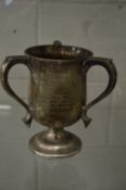 A silver three handled trophy cup.