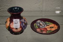 A small Moorcroft vase with matching circular dish.