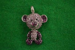A teddy bear pendant.