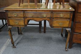 A walnut dressing table or writing table with an arrangement of five small drawers on carved