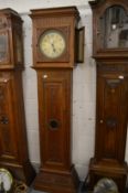 A Continental oak longcase clock with carved decoration, later circular dial and movement.