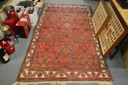 A Persian carpet, red ground with stylised decoration 220cm x 130cm.
