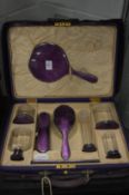 A good ladies purple leather vanity case with outer cover, the interior fitted with purple enamelled