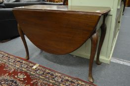 A Georgian style mahogany oval drop leaf gateleg dining table on carved cabriole legs with pointed