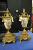 A pair of ormolu style and porcelain urn shaped ornaments (af).