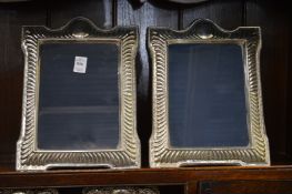 A pair of large silver photograph frames.