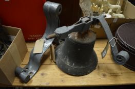 An old bronze bell with wrought iron bracket.