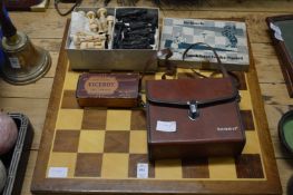 Chess board with chess pieces, binoculars, and a razor.