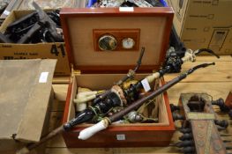 A cigar humidor and a quantity of smoking pipes.
