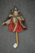 A Victorian children's toy modelled as a jester with porcelain head and turned wood handle.