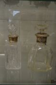A cut glass whisky decanter with silver collar together with an engraved decanter with silver