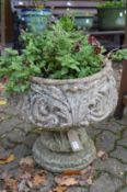 A pair of weathered garden pedestal planters.