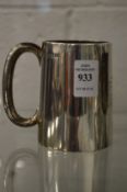 A small silver tankard with engraved inscription.