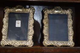A pair of silver photograph frames with embossed decoration.