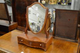 A small mahogany shield shape toilet mirror with serpentine fronted base.