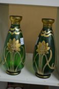 A pair of gilt decorated green glass vases.