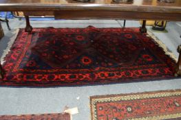 A Persian design rug with dark blue ground and stylised decoration 200cm x 130cm.