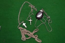 A filigree silver pendant and two crosses.