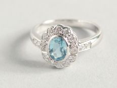 AN 18CT WHITE GOLD AQUAMARINE AND DIAMOND OVAL RING.