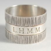 A DESIGNER SILVER BARK FINISH SERVIETTE RING.