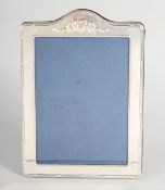 A LARGE SILVER UPRIGHT PHOTOGRAPH FRAME with ribbons motif. 7ins x 6.5ins.