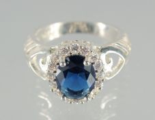 A SILVER AND BLUE STONE RING.