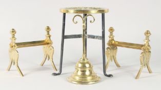 A CIRCULAR BRASS TRIVET, A PAIR OF ANDIRONS and a doorstop (4).