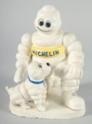 A PAINTED CAST IRON MICHELIN MAN with a dog. 8ins high.