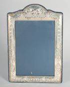 A LARGE SILVER UPRIGHT PHOTOGRAPH FRAME with ribbons motif. 9ins x 6.5ins.