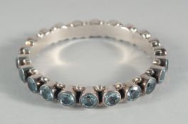 A STERLING SILVER AND BLUE TOPAZ BANGLE.