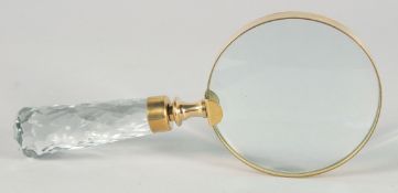 A MAGNIFYING GLASS with a cut glass handle.