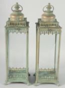 A PAIR OF TIN SQUARE LANTERNS with carrying handles on square feet. 20ins.