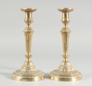 A GOOD PAIR OF 18TH CENTURY FRENCH ORMOLU CIRCULAR CANDLESTICKS on circular bases. 11ins high.