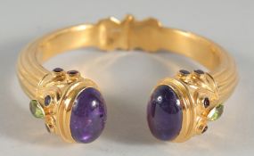 A GOLD PLATED STERLING SILVER, AMETHYST AND PERIDOT BANGLE.