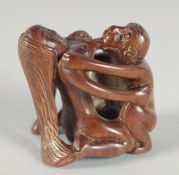 A CARVED WOOD EROTIC NETSUKE. 1.75ins high.
