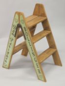 A PAIR OF NOVELTY CHAMPAGNE WOODEN FOLDING STEPS. 30ins high.