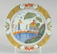 A RARE 18TH CENTURY DUTCH FAIENCE POLYCHROME PLATE shallow rounded form painted with a figure,