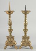 A GOOD PAIR OF DUTCH BRASS CANDLESTICKS on a triangular base with claw and ball feet. 15ins high.