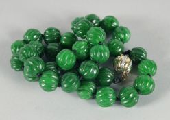 A VERY GOOD STRING OF JADE BEADS with 14ct gold and diamond clasp. 18ins long.