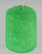 A CARVED JADE PENDANT with gold ring. 2.25ins