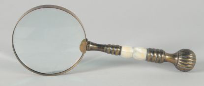 A MAGNIFYING GLASS with a chrome and brass handle.