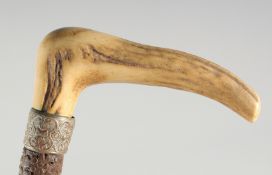 A GOOD VICTORIAN WALKING STICK with carved bone handle and silver band.