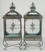 A GOOD PAIR OF TIN GLAZED LANTERNS on curving stands with carrying handles. 27ins.