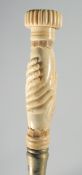 A CARVED BONE CLASPED HAND HANDLED WALKING STICK.