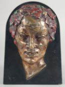 A BRONZE MALE MASK mounted to a marble background. 9ins high. Signed R. De Ryr