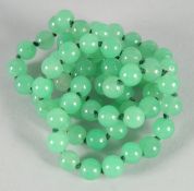 A STRING OF JADE BEADS 26ins long.